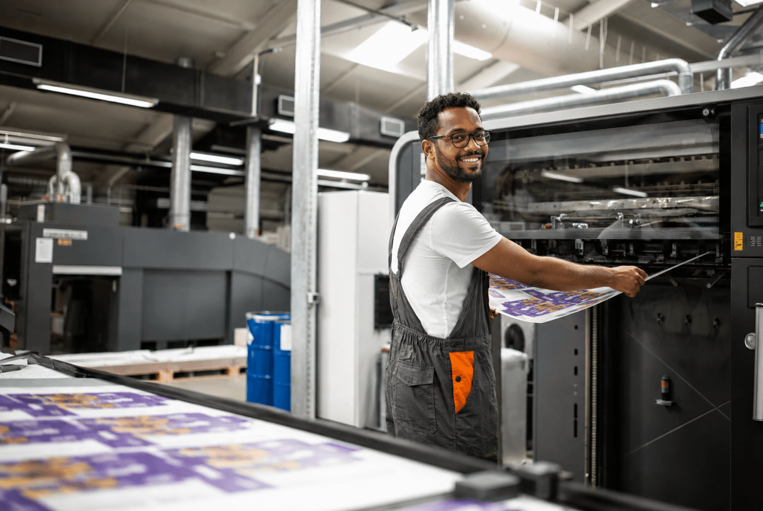 A Fulas press operator with a freshly printed sheet